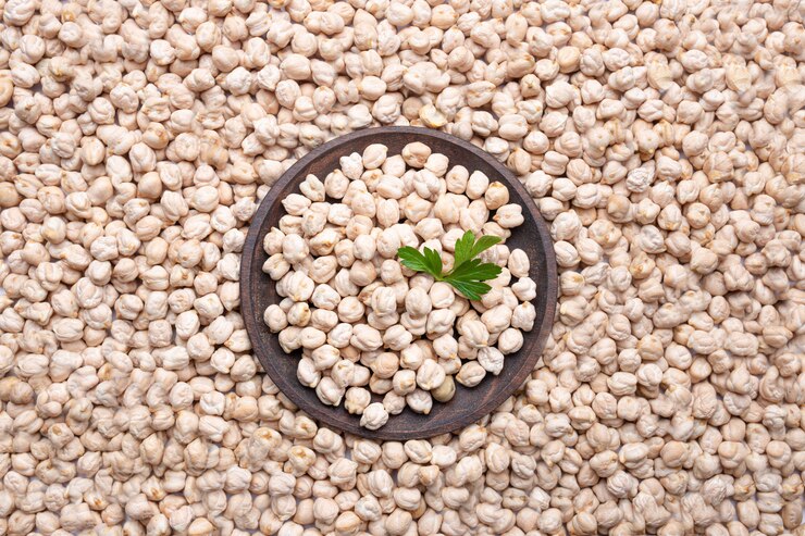 bowl of white beans garnished with a parsley leaf, highlighting Ashwini Chickpeas' 24.8% protein and disease resistance.